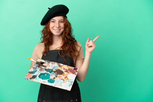 Teenager Redhead Artist Holding Palette Isolated Green Background Pointing Finger — Stock Photo, Image