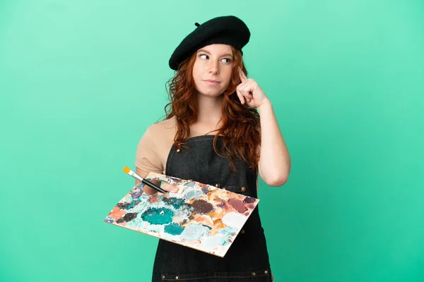 Teenager Redhead Artist Holding Palette Isolated Green Background Having Doubts — Stock Photo, Image