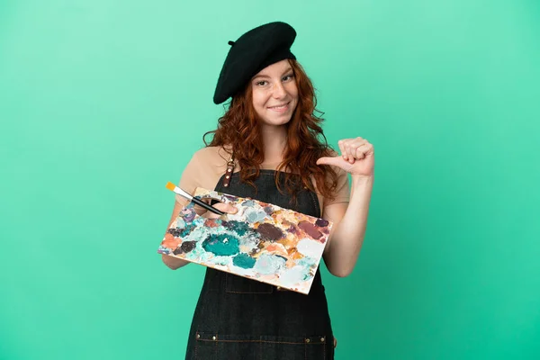 Nastoletni Rudowłosy Artysta Trzymając Paletę Odizolowanych Zielonym Tle Pokazując Kciuk — Zdjęcie stockowe