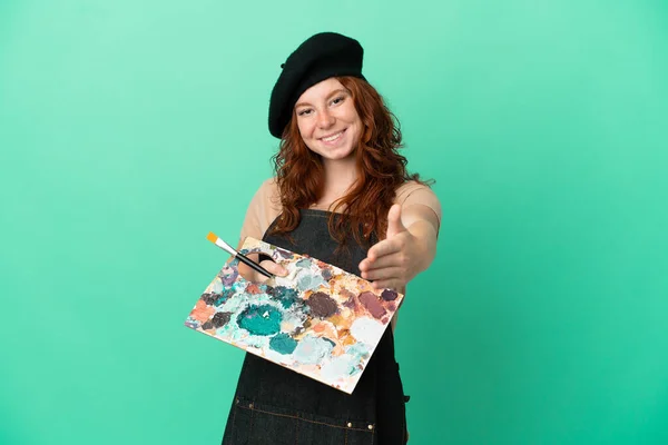 Nastoletni Rudowłosy Artysta Trzymając Paletę Odizolowanych Zielonym Tle Ściskając Dłonie — Zdjęcie stockowe