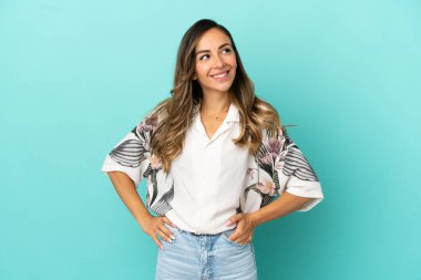 Soyutlanmış mavi arka planda genç bir kadın yukarı bakarken bir fikir düşünüyor.