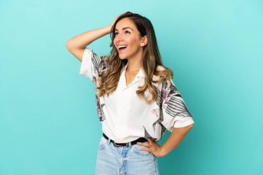 Soyutlanmış mavi arka planda genç bir kadın. Çok gülümsüyor.