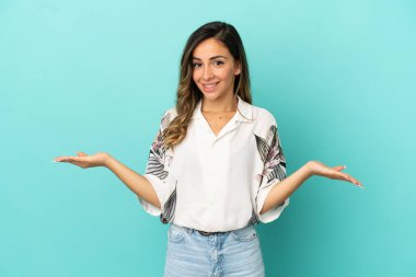 İzole edilmiş mavi arka planı olan genç bir kadın.