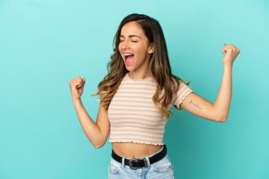 Genç bir kadın mavi arka planda zaferi kutluyor.