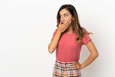 İzole edilmiş arka planda kalan genç bir kadın yan tarafa bakarken sürpriz jest yapıyor.