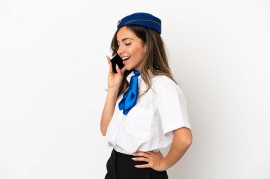 İzole edilmiş beyaz arka planda uçak hostesi cep telefonuyla sohbet ediyor.