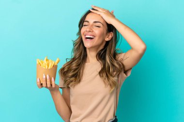 Kızarmış cipsleri izole edilmiş arka planda tutan genç bir kadın çok gülümsüyor.