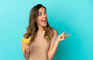 Kızarmış cipsleri izole edilmiş arka planda tutan genç bir kadın parmak kaldırarak çözümü anlamaya çalışıyor.