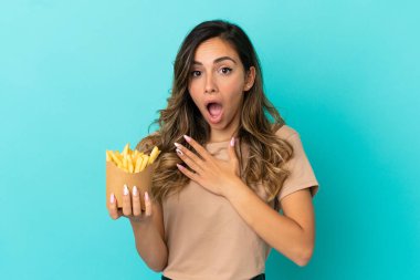 Kızarmış cipsleri arka planda tutan genç bir kadın sağa bakarken şaşırmış ve şok olmuştu.