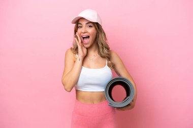 Genç sporcu kadın, elinde sürpriz ve şok olmuş yüz ifadesiyle yoga derslerine gidiyor.