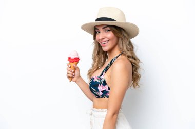 Mayo giyen ve beyaz arka planda izole edilmiş, bol bol gülümseyen kornet dondurma tutan bir kız.