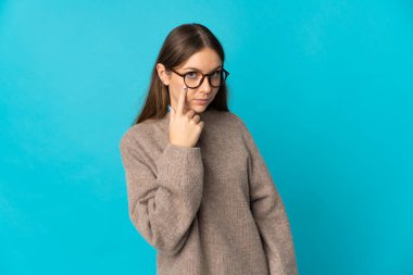 Genç Litvanyalı bir kadın mavi arka planda izole edilmiş.