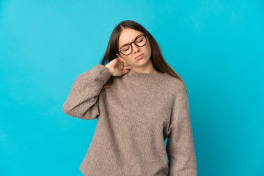 Genç Litvanyalı kadın mavi arka planda izole edilmiş ve boynu ağrıyor.