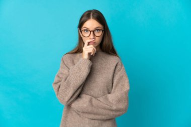 Genç Litvanyalı kadın mavi arka planda izole edilmiş, sağa bakarken şaşırmış ve şok olmuştu.