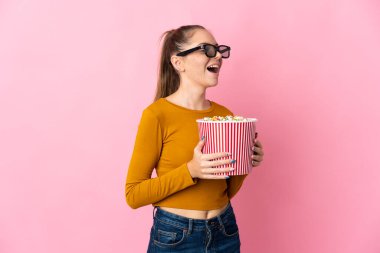 Genç Litvanyalı bir kadın pembe arka planda gözlüklü ve elinde koca bir kova patlamış mısır tutuyordu.