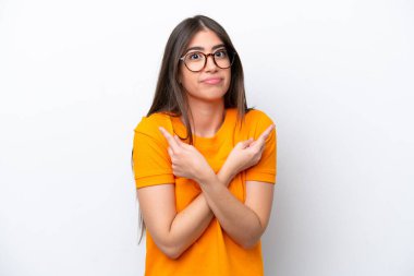 Beyaz arka planda izole edilmiş genç beyaz kadın, yan taraftakilerin şüphelerine işaret ediyor.