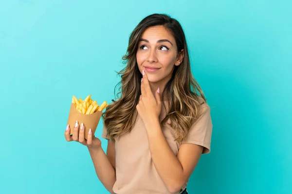 Young Woman Holding Fried Chips Isolated Background Looking While Smiling — Stock Fotó