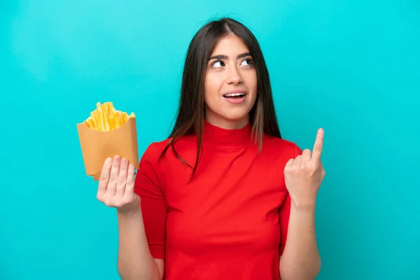 Young Caucasian Woman Catching French Fries Isolated Blue Background Thinking — стоковое фото