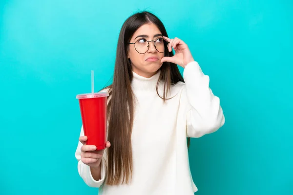 Νεαρή Καυκάσια Γυναίκα Πίνει Σόδα Απομονωμένη Μπλε Φόντο Σκεπτόμενη Μια — Φωτογραφία Αρχείου