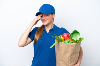 Genç teslimatçı kadın beyaz arka planda izole edilmiş bir paket yiyecek alıyor.