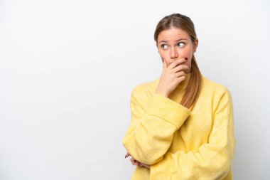 Beyaz arka planda izole edilmiş genç beyaz bir kadın. Şüpheleri var ve kafası karışmış bir yüz ifadesi var.