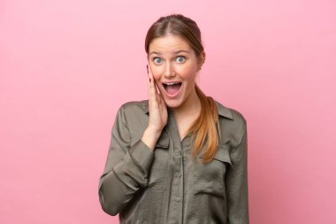 Pembe arka planda izole edilmiş beyaz bir kadın. Şaşırmış ve şok olmuş bir yüz ifadesi var.