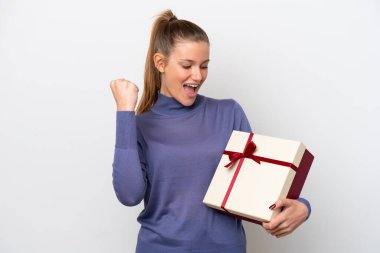 Beyaz arka planda izole edilmiş bir hediye taşıyan beyaz bir kadın zaferi kutluyor.