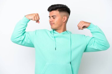 Beyaz arka planda izole edilmiş beyaz, yakışıklı genç bir adam güçlü bir jest yapıyor.
