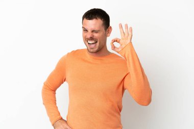 İzole edilmiş beyaz arka plan üzerinde Brezilyalı bir adam parmaklarıyla tamam işareti gösteriyor