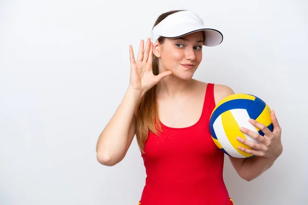 Молодая Белая Женщина Играет Волейбол Белом Фоне Слушая Прикладывая Руку — стоковое фото