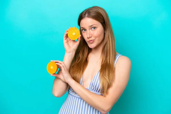 Młoda Kobieta Odizolowana Niebieskim Tle Stroju Kąpielowym Trzymająca Pomarańczę — Zdjęcie stockowe