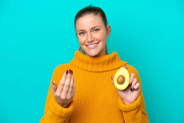 Egy Fiatal Kaukázusi Egy Avokádót Tart Elszigetelve Kék Hátterétől Kézen — Stock Fotó