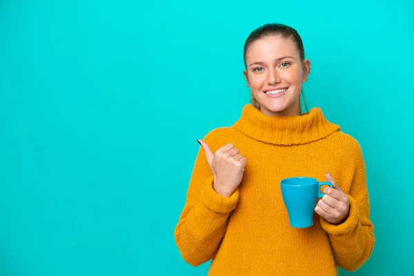 Mulher Branca Jovem Segurando Copo Isolado Fundo Azul Apontando Para — Fotografia de Stock