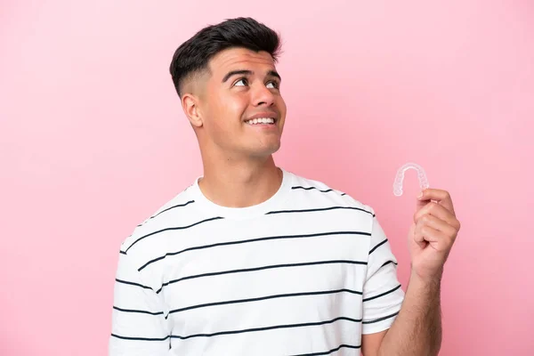 Young Caucasian Man Holding Invisaling Isolated Pink Background Looking While — 스톡 사진