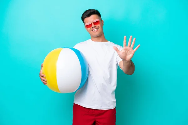 Young Caucasian Man Holding Beach Ball Isolated Blue Background Counting — 스톡 사진