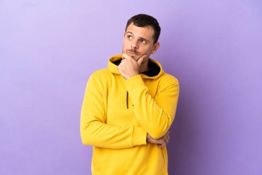 İzole edilmiş mor arka planı olan Brezilyalı adamın şüpheleri var.