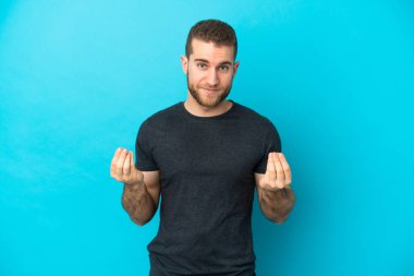 Genç yakışıklı beyaz adam mavi arka planda izole edilmiş para hareketi yapıyor ama mahvoldu.