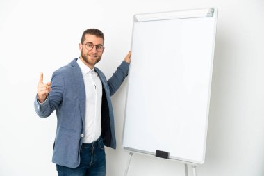 Beyaz arka planda beyaz tenli yakışıklı bir adam beyaz panoda sunum yapıyor.