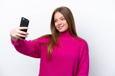 Beyaz arka planda izole edilmiş beyaz bir kadın selfie çekiyor.