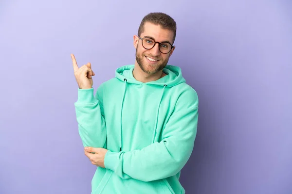 Young Handsome Caucasian Man Isolated Purple Background Happy Pointing — Stock fotografie