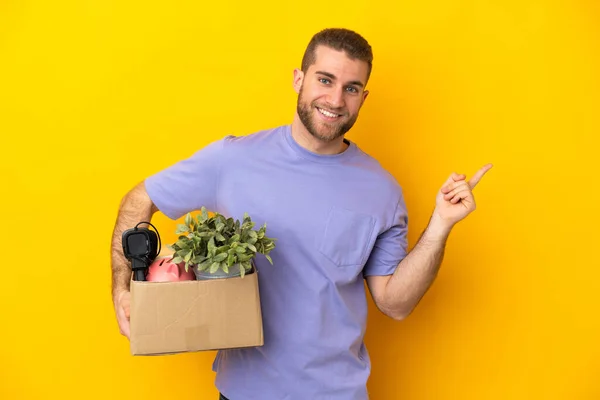 Young Caucasian Making Move While Picking Box Full Things Isolated — Φωτογραφία Αρχείου