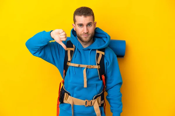 Young Caucasian Mountaineer Man Big Backpack Isolated Yellow Background Showing —  Fotos de Stock