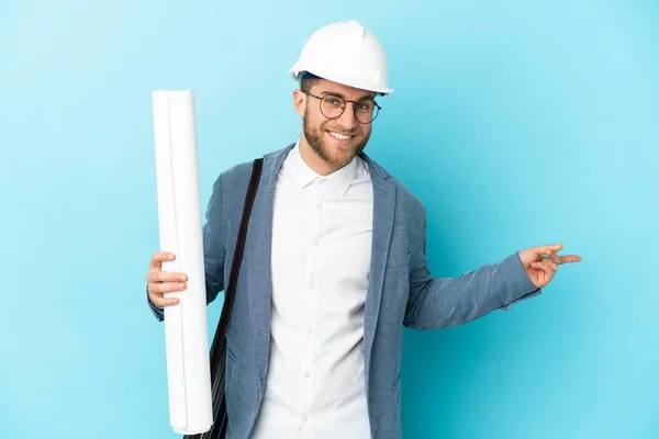 Young Architect Man Helmet Holding Blueprints Isolated Background Pointing Finger — стоковое фото