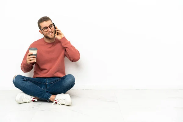 Νεαρός Όμορφος Άνδρας Κάθεται Στο Πάτωμα Κρατώντας Καφέ Για Πάρει — Φωτογραφία Αρχείου