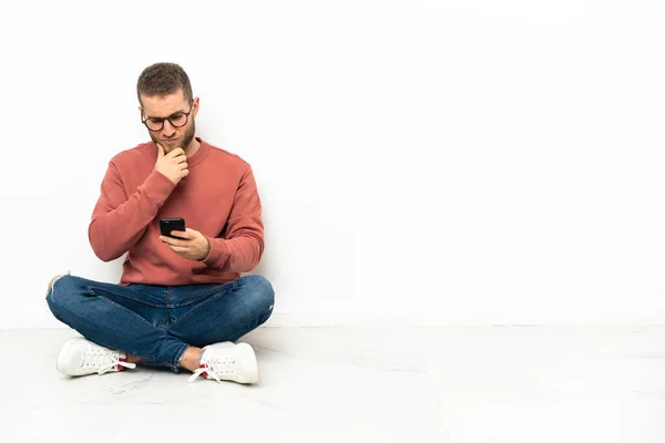 Young Handsome Man Sitting Floor Thinking Sending Message — Stockfoto