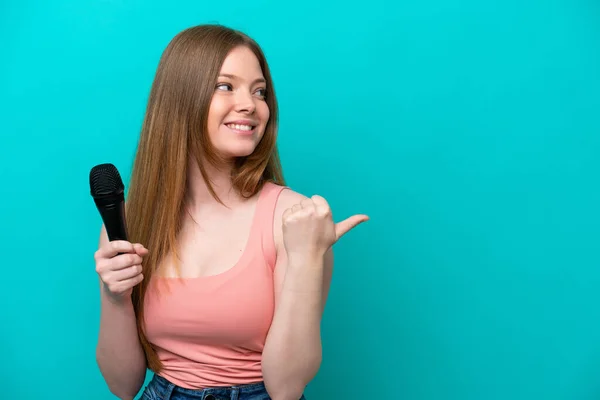 Kafkasyalı Şarkıcı Mavi Arka Planda Izole Edilmiş Bir Mikrofonu Kaldırıyor — Stok fotoğraf