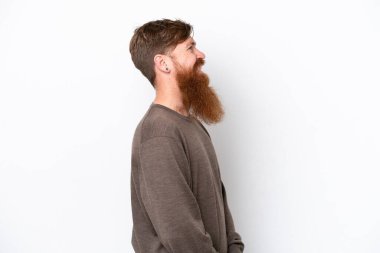 Sakallı kızıl saçlı adam, beyaz arka planda, yan pozisyonda izole edilmiş.