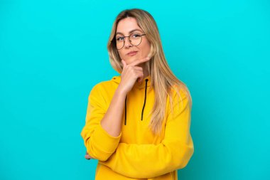 Genç Uruguaylı kadın mavi arka planda izole edilmiş mutlu ve gülümsüyor.