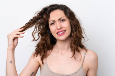 Beyaz arka planda saçları karışık, beyaz tenli genç bir kadın. Portreyi kapat