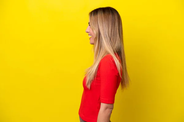 Junge Uruguayische Frau Isoliert Auf Gelbem Hintergrund Lacht Seitenlage — Stockfoto
